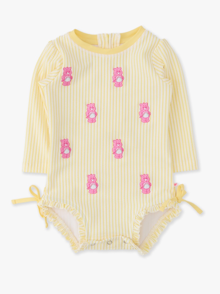 Line drawing of Banana Seersucker Cheer Bear Care Bears Seersucker Long Sleeve One Piece Rash Guard Swimsuit, with Signature Rear Ruffles. A dotted circle indicates the approximate location for personalization.