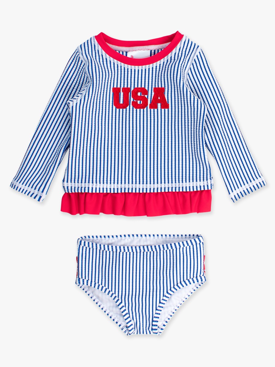 Line drawing of Red USA Embroidered Blue Seersucker Long Sleeve Rash Guard 2-Piece Swimsuit, with Signature Rear Ruffles. A dotted circle indicates the approximate location for personalization.