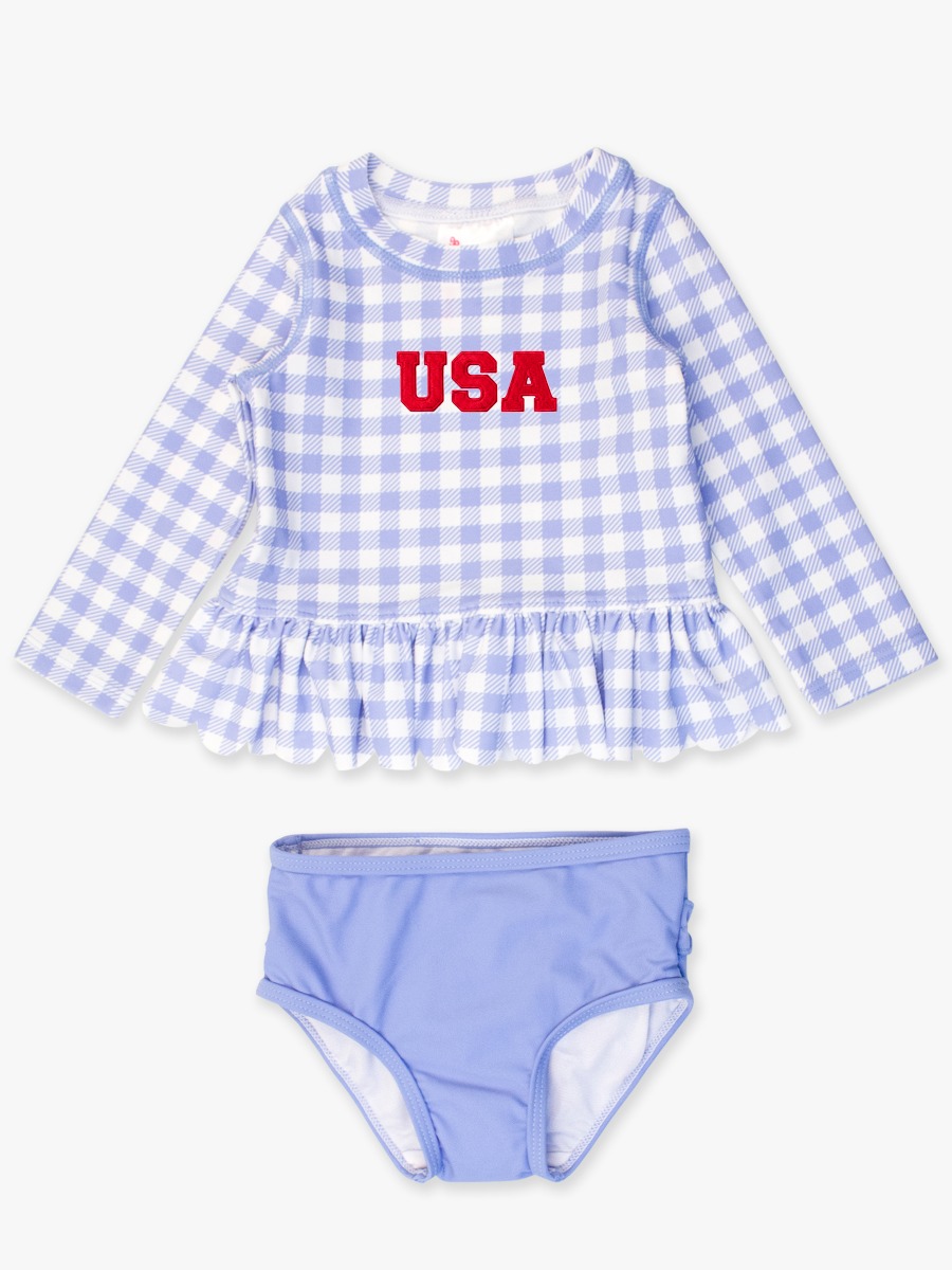 Line drawing of Red USA Embroidered Periwinkle Blue Gingham Scallop Hem Long Sleeve Rash Guard 2-Piece, with Signature Rear Ruffles. A dotted circle indicates the approximate location for personalization.