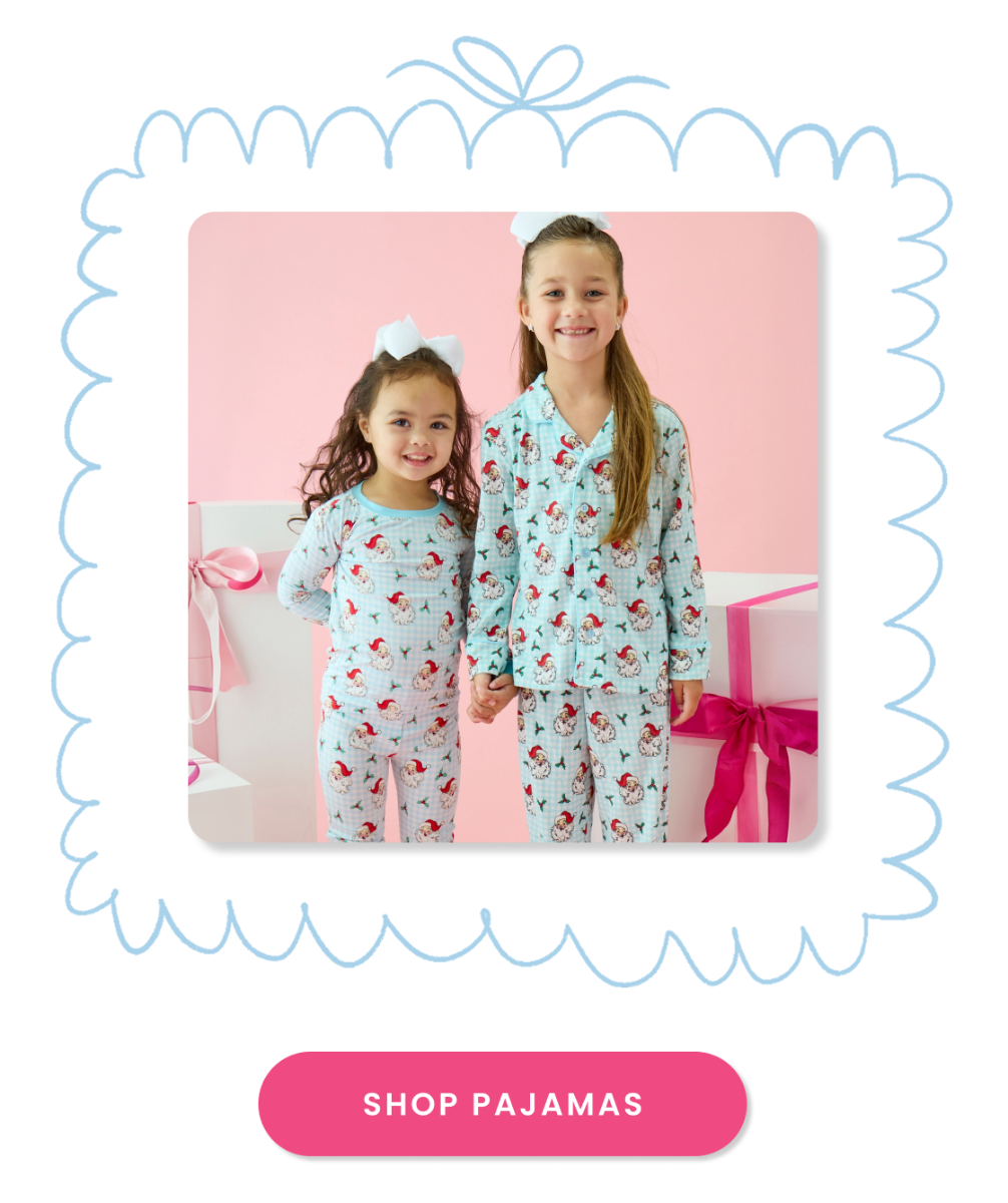 "Banner showing matching blue Santa-print pajamas framed by gift-themed illustrations. Includes a pink &lsquo;Shop Pajamas&rsquo; button."
