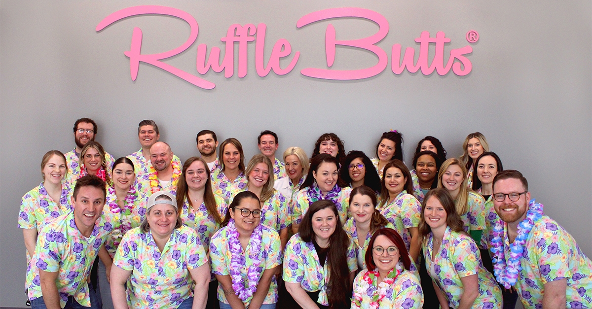 RuffleButts team poses for picture in Aloha Blossoms shirts