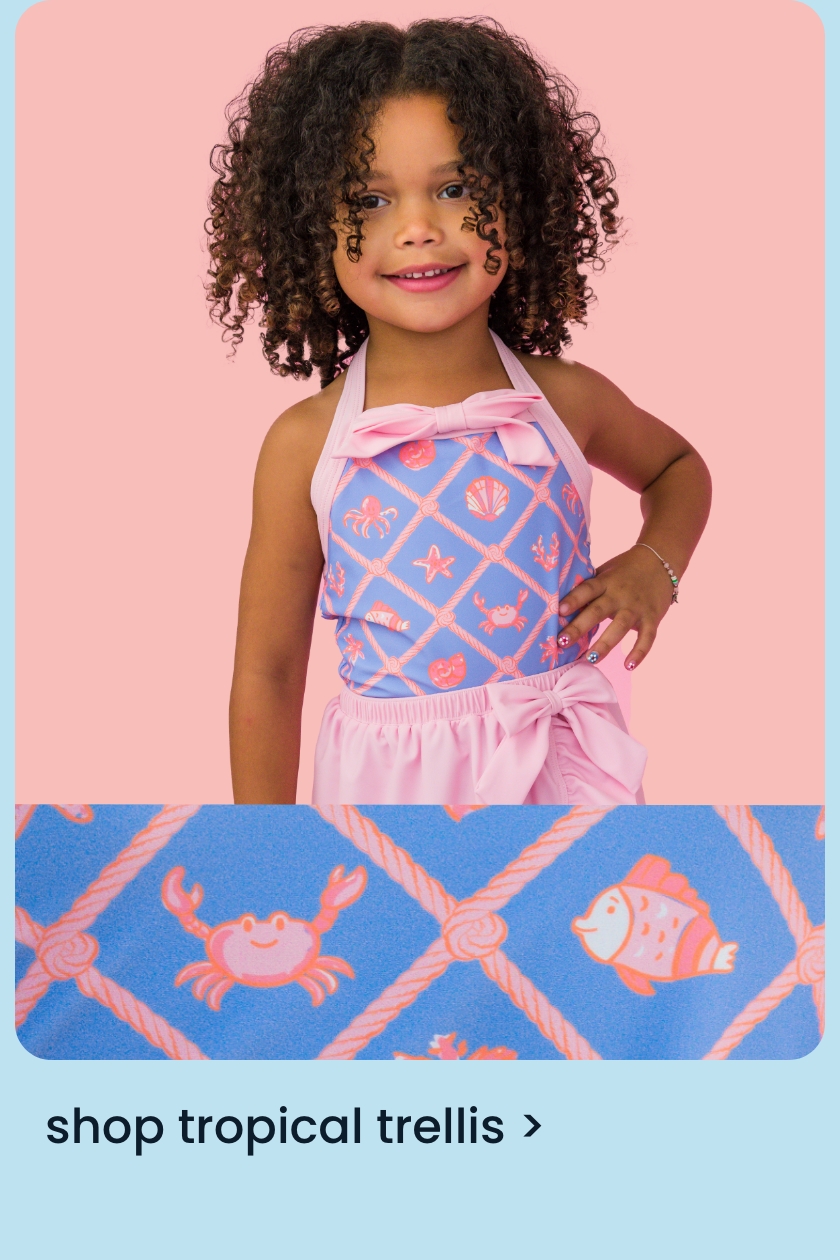 Child wearing a pink halter swimsuit with blue tropical trellis print featuring crabs, fish, and seashells.  Text says "shop tropical trellis"