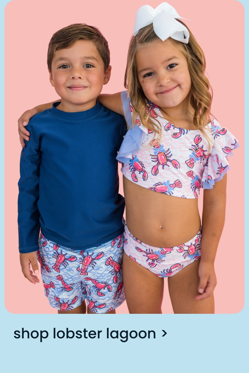 Two children wearing Lobster Lagoon swimwear; one in a blue long-sleeve rash guard with lobster-print trunks, the other in a pink lobster-print ruffle bikini. Text: &ldquo;Shop Lobster Lagoon.&rdquo;