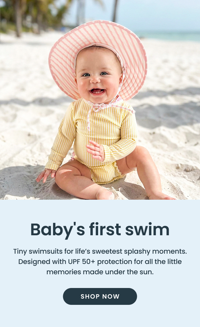"Banner showing a baby in a yellow long‑sleeve swimsuit and pink striped sun hat sitting on a sandy beach. Text reads ‘Baby’s first swim’ with UPF 50+ mention and a ‘Shop Now’ button."