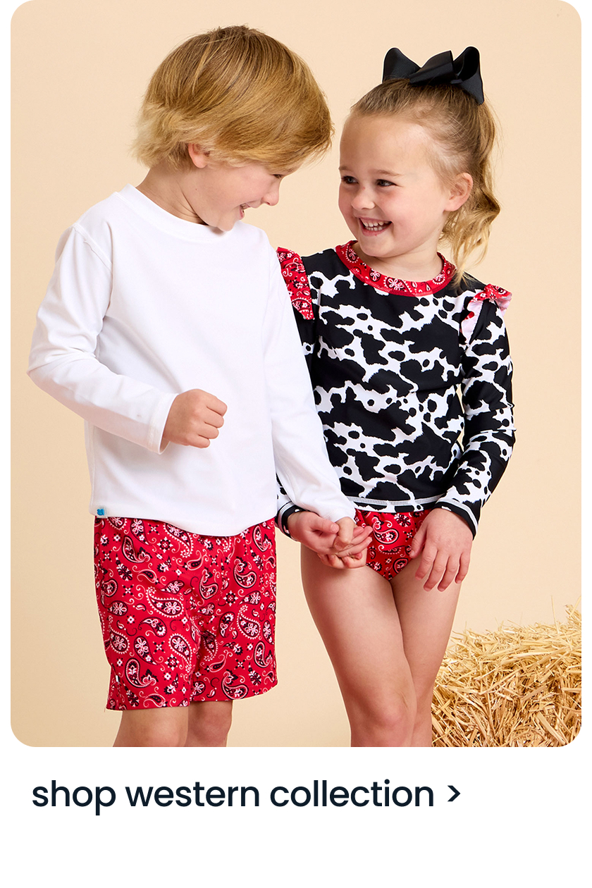 "Two children wearing western‑inspired outfits, including cow‑print and red bandana styles, standing near hay. Text below reads ‘shop western collection.’"