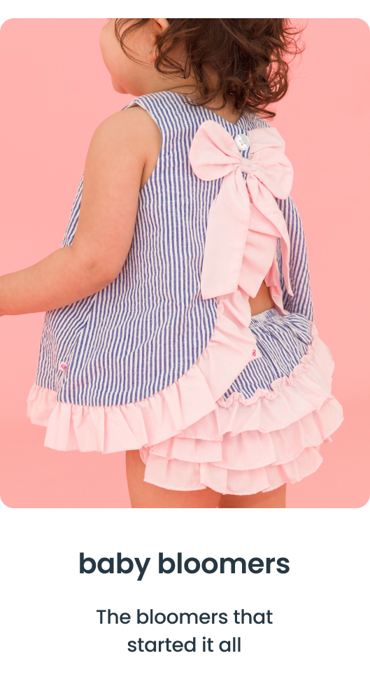 "Close‑up of a striped top with a large pink bow and matching pink ruffle bloomers on a pink background. Text reads &lsquo;baby bloomers&rsquo; and &lsquo;The bloomers that started it all.&rsquo;"