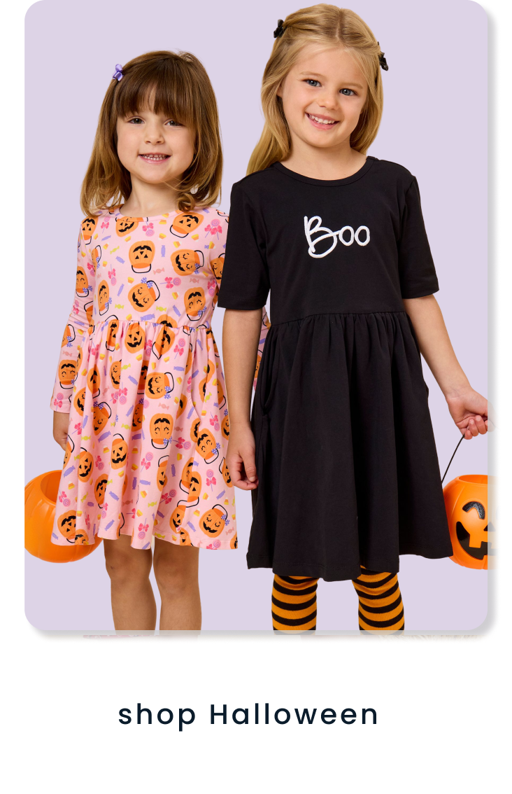 "Children wearing Halloween-themed dresses featuring pumpkin prints and a ‘Boo’ design, holding pumpkin pails. Text below reads ‘shop halloween.’"