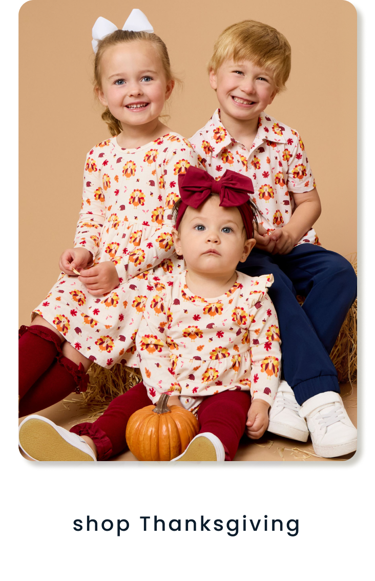 "Children wearing coordinating turkey-print apparel with autumn colors and a pumpkin accent. Text below reads ‘shop thanksgiving.’"
