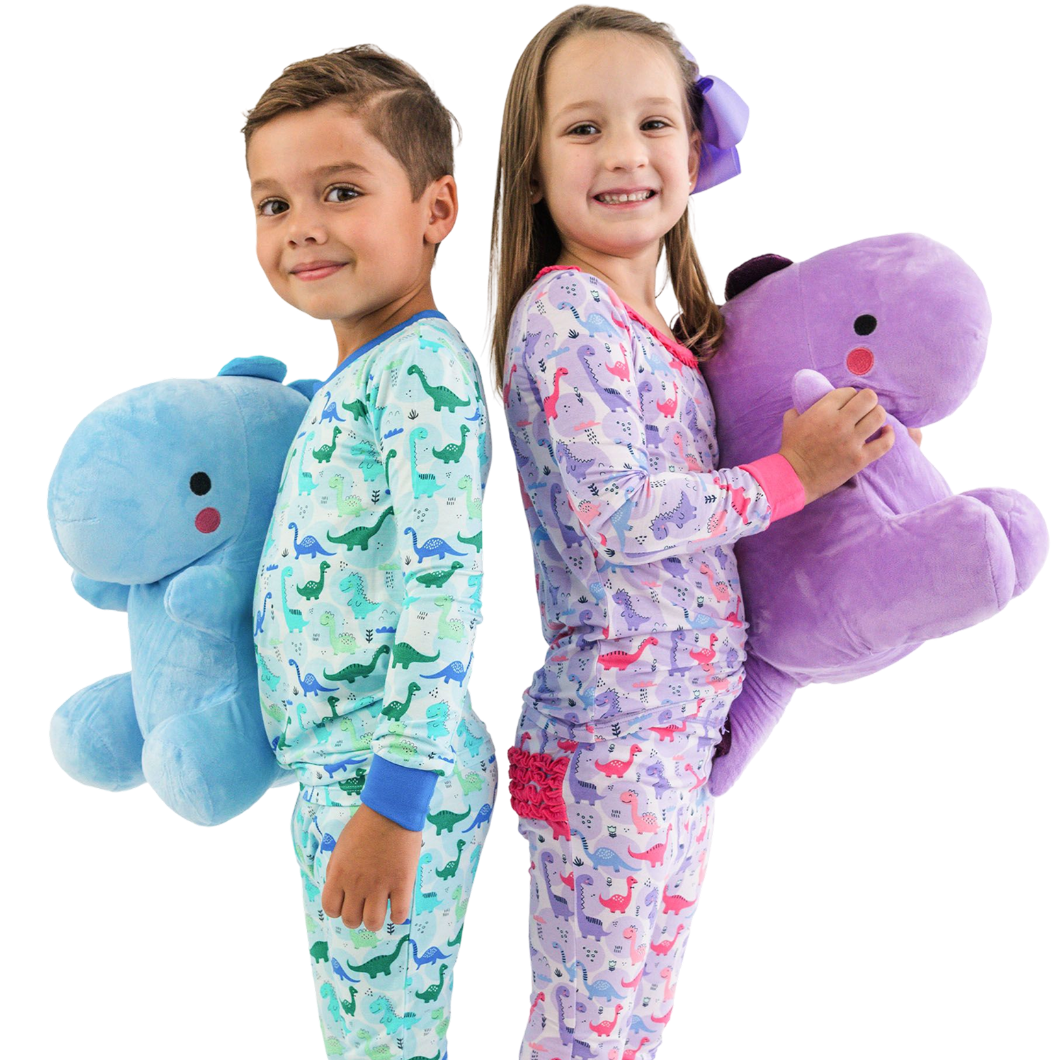 Promotional image showing two children wearing dinosaur-print pajamas and holding plush dinosaur toys. One pajama set features blue and green dinosaurs, and the other pink and purple dinosaurs.&rdquo;