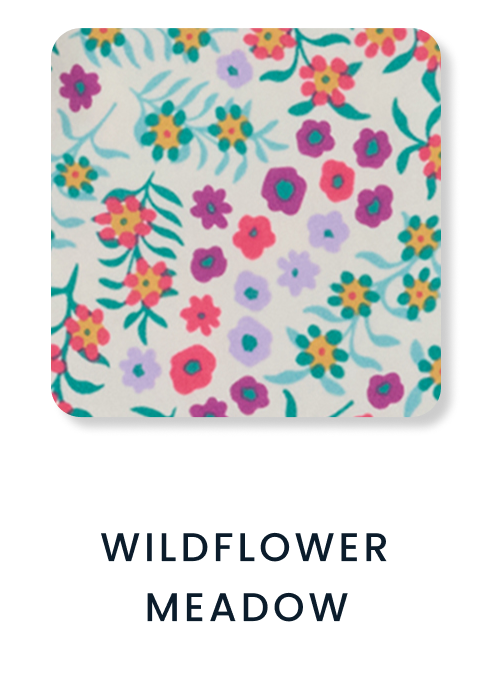 Shop By Print tile featuring a navy pattern with colorful bows in pink, purple, green, gold, and white. Text reads ‘Cozy Bows.’