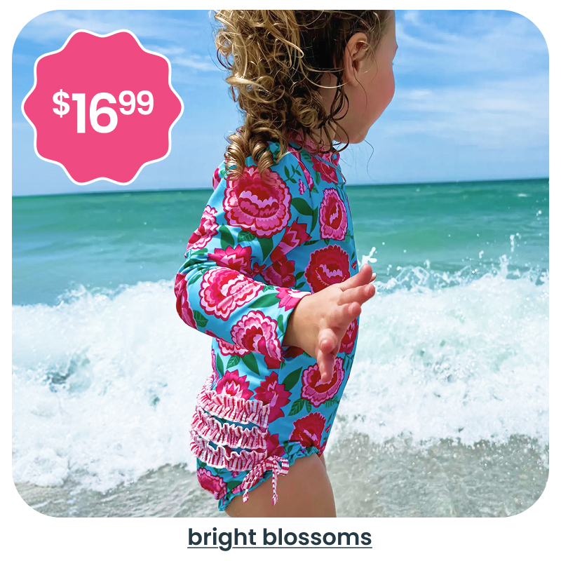 "Beach image showing a child in a bright floral long‑sleeve swimsuit by ocean waves. Pink badge reads &lsquo;$16.99.&rsquo; Text below reads &lsquo;bright blossoms.&rsquo;"
