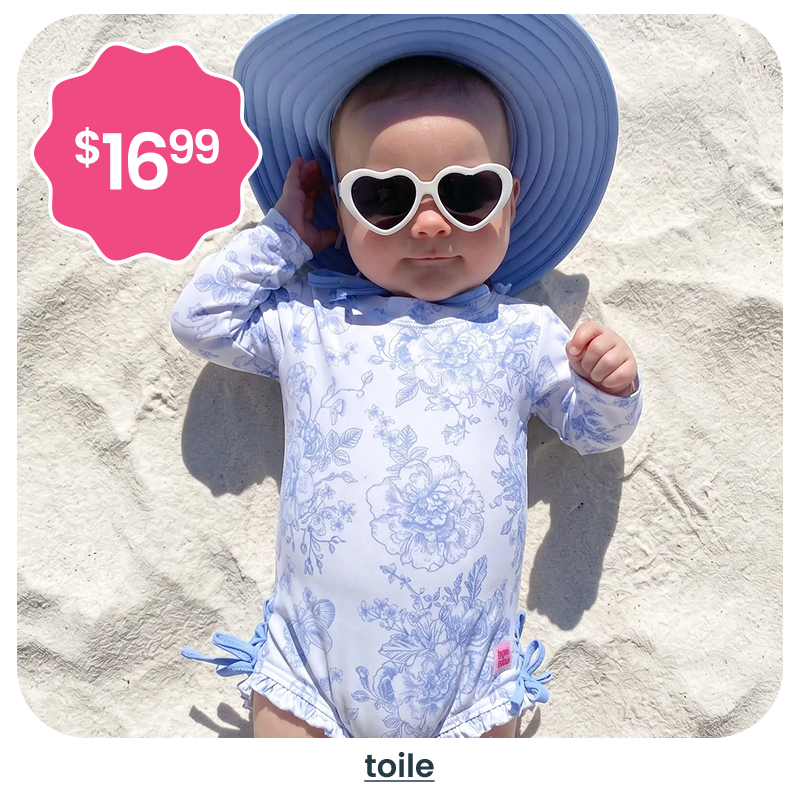 "Beach image showing a baby in a light blue toile‑print long‑sleeve swimsuit with a wide sun hat and sunglasses. A pink badge reads &lsquo;$16.99.&rsquo; Text below reads &lsquo;toile.&rsquo;"